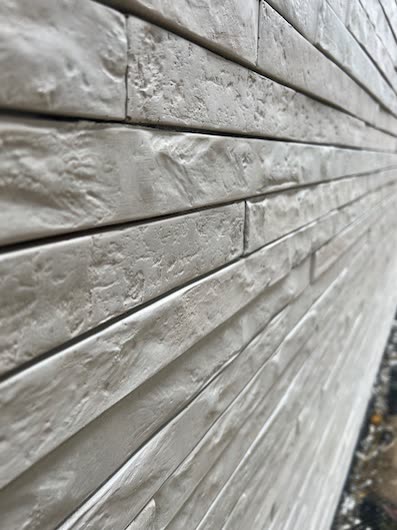 Zbliżenie na jasną, ręcznie formowaną płytkę licową ułożoną w regularnym pasie — detal realizacji WNĘTRZA.COM