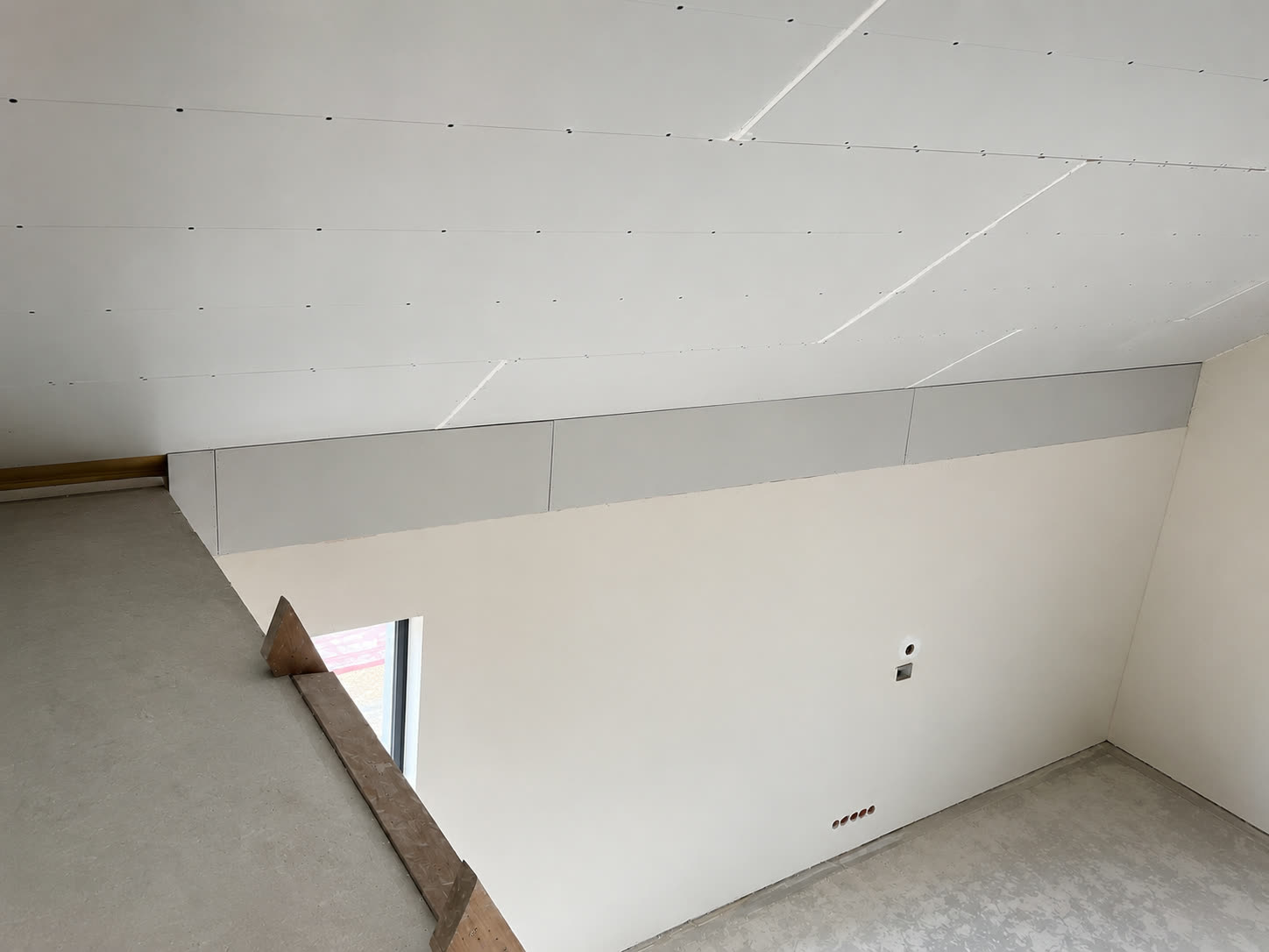 Zabudowa skosów poddasza z płyt gipsowo-kartonowych z ostrą krawędzią balustrady — realizacja WNĘTRZA.COM w Skórzewie